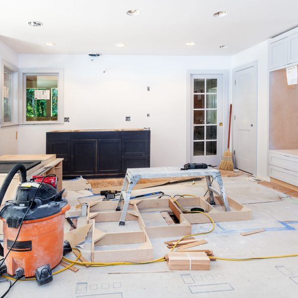 Custom kitchen cabinets in various stages of installation; base for island in center